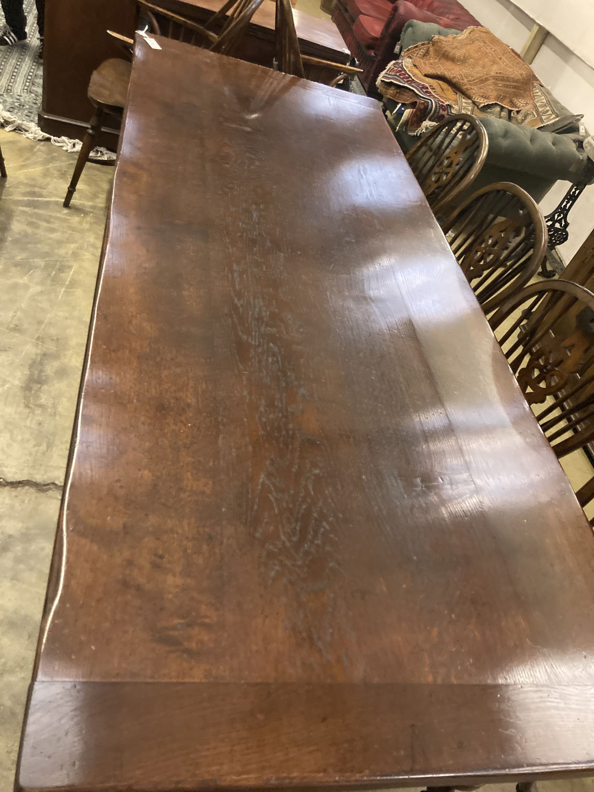 An 18th century style oak refectory table having planked top on double turned end supports, width 230cm depth 90cm height 76cm